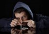 30439400-young-drug-addict-man-on-hood-alone-sniffing-and-snorting-cocaine-lines-with-rolled-b...jpg